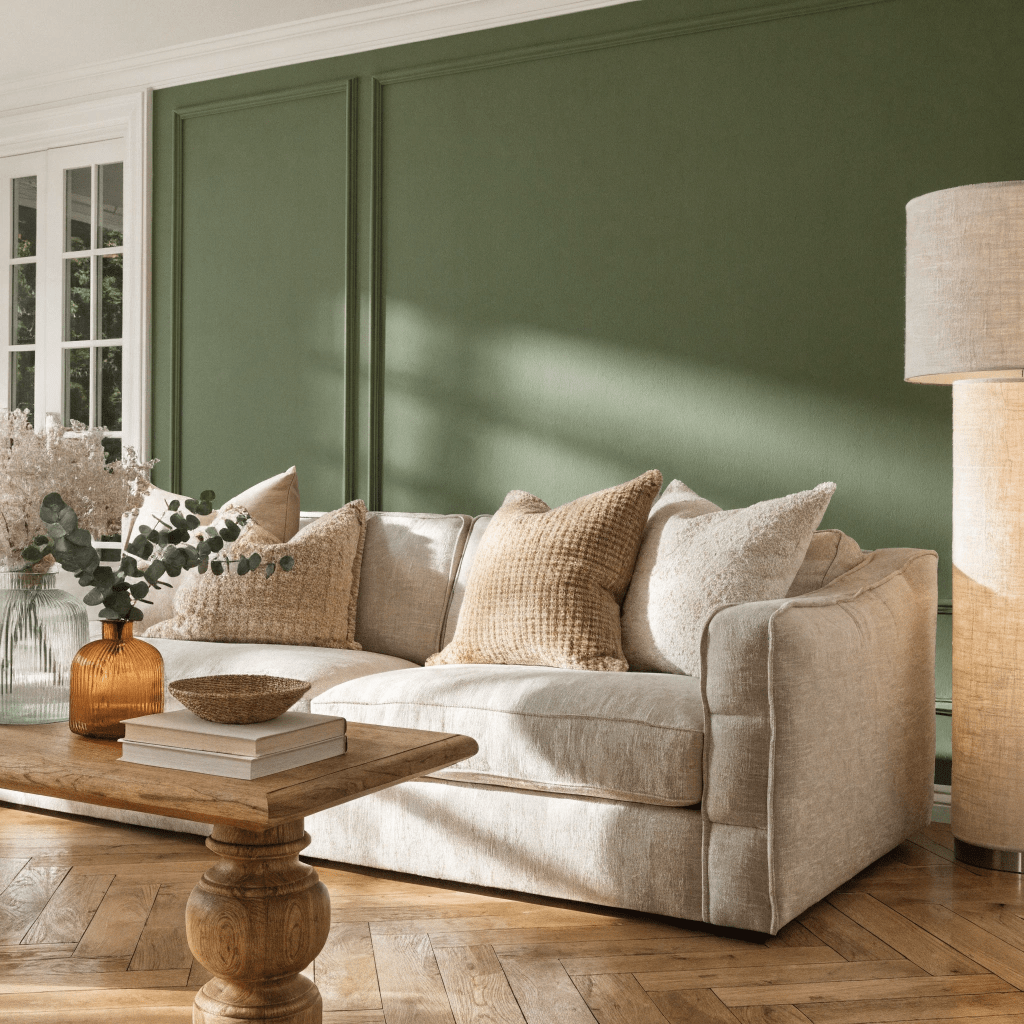 An olive green accent wall brings natural warmth and depth to this cozy living space.